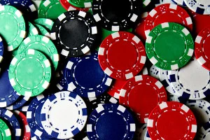 Scattered black, red, white, blue, and green poker chips